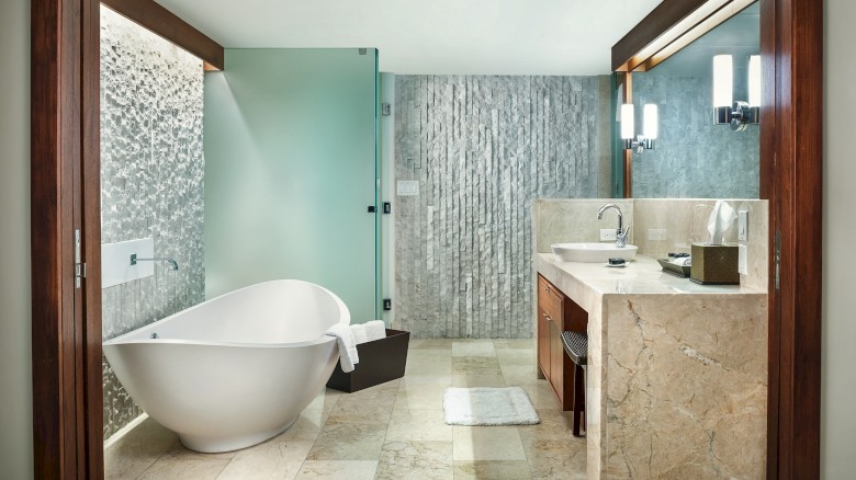 Luxurious bathroom with a freestanding tub, glass shower, marble sink, and stylish lighting.
